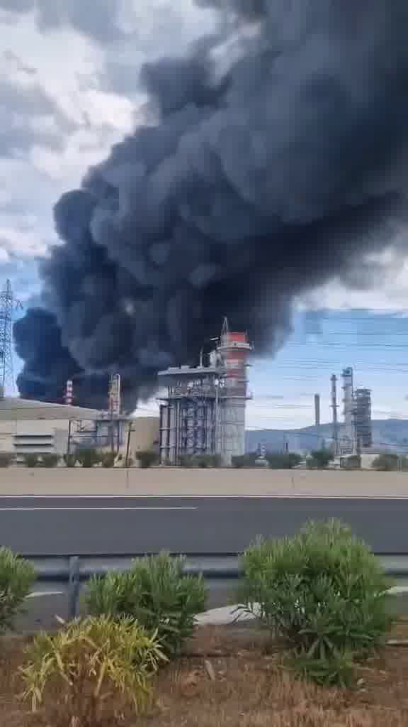 Na Grécia, um grande incêndio está ocorrendo na refinaria de óleo de motor em Agioi Theodorou. O corpo de bombeiros relatou que antes do incêndio começar, houve uma forte explosão. Os serviços de emergência estão no local